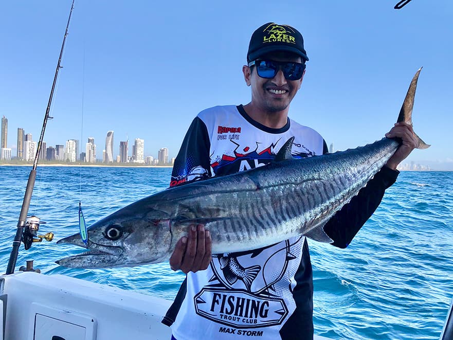 Angler in a Lazer Lures cap holding a Spanish mackerel